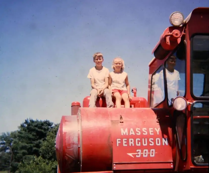 Sara Wyant and sibling sitting on a Massey Ferguson 300 tractor on their family farm. 